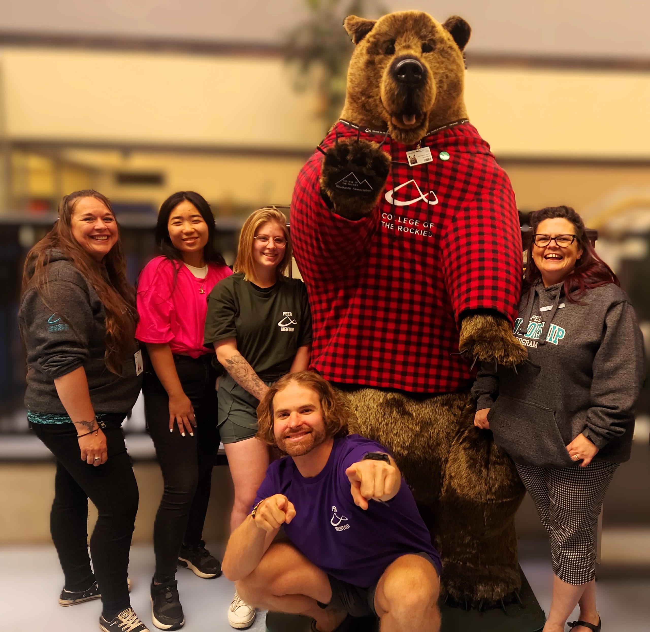 Group of Peer Mentors posing with COTR Students' Association mascot.