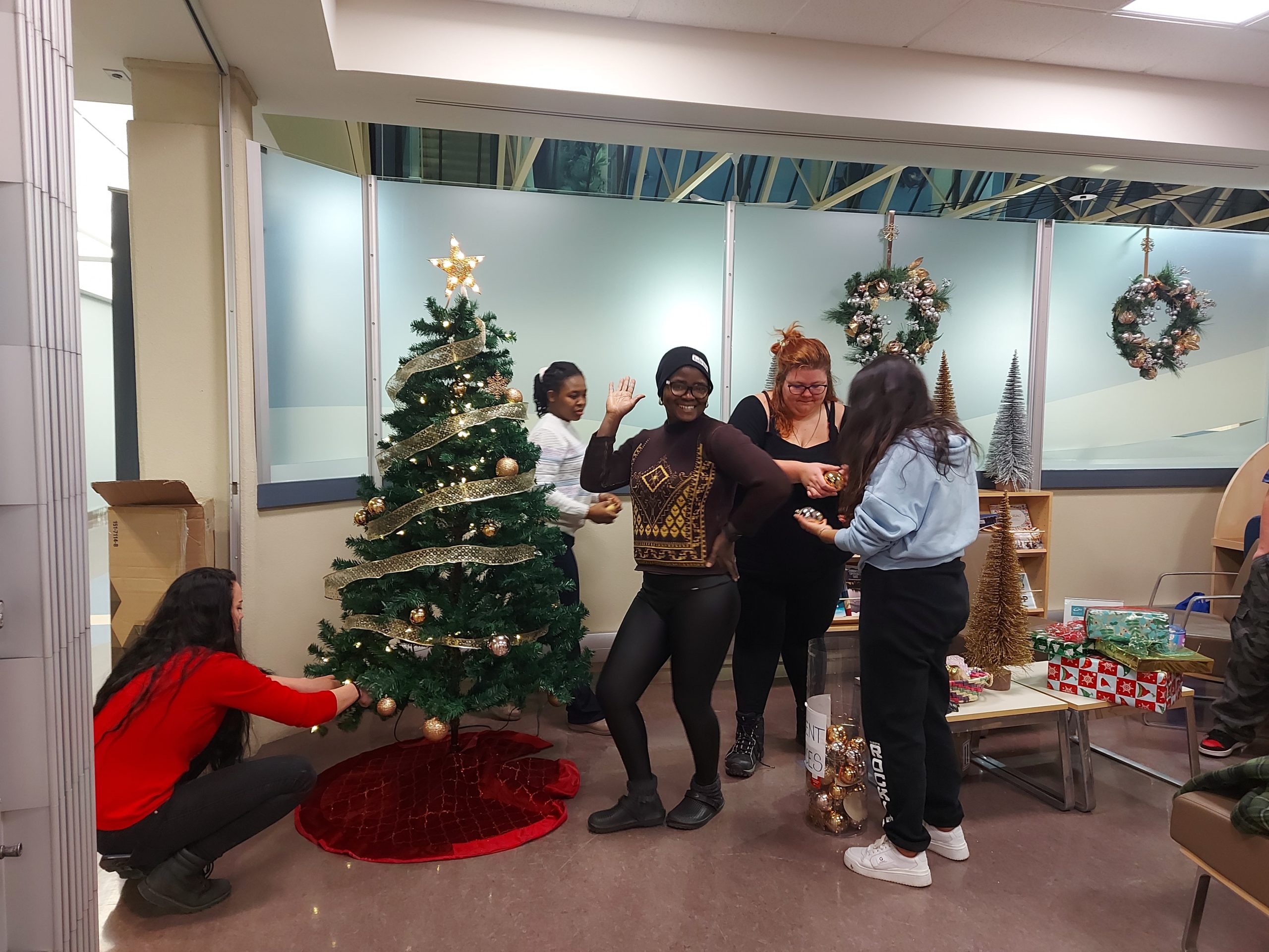 Group of students and mentors decorating a Christmas tree.